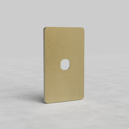 Antique Brass 1G Switch Plate Grove US with rounded corners and central switch cutout on a light surface.