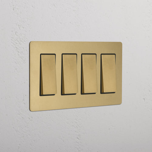 Kew 4G Rocker Switch in antique brass black with four rectangular switches, shown on a white wall.