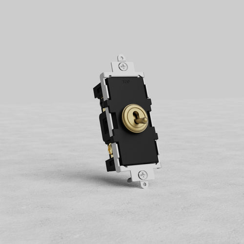 Four Way Toggle Switch in antique brass finish, shown upright on a light gray textured surface.