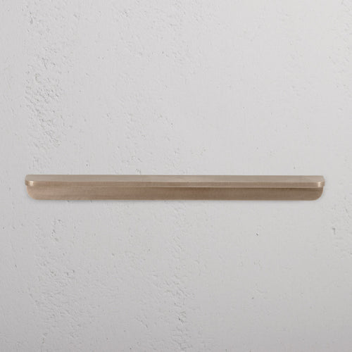Antique brass Oxford Furniture Handle Medium, mounted on a white surface, shown in close-up view.
