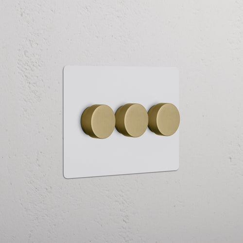 Kew 3G Dimmer Switch in paintable antique brass finish with three round knobs on a white plate.