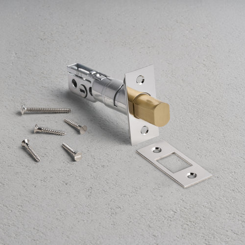 Tubular Privacy Deadbolt in Polished Nickel with strike plate and screws on a light gray surface.