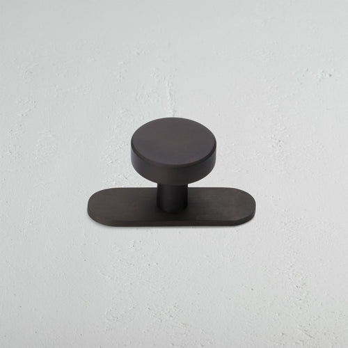 Kilburn Furniture Knob in bronze finish, featuring a circular handle and rounded rectangular base.