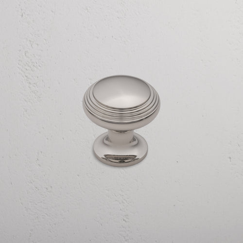 Barlow Furniture Knob Medium in polished nickel with subtle grooves, shown mounted on a white wall.
