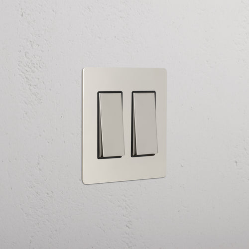 Kew 2G Rocker Switch in Polished Nickel Black with a sleek metallic finish, mounted on a wall.