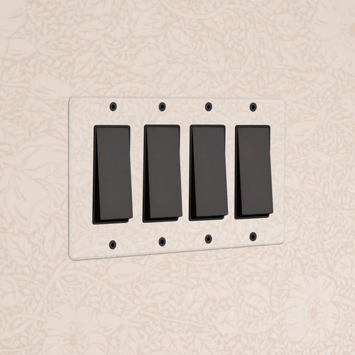 Kew 4G Rocker Switch in Clear Bronze Black with four black switches on a clear bronze wall plate.