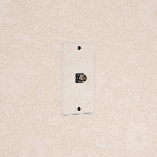 Kew 1G TV Keystone - Clear Black wall plate for coaxial TV cable connection, shown on a beige wall.
