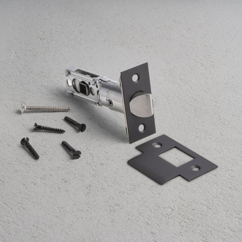 Bronze passage tubular latch assembly with rectangular faceplate, screws, and mounting plate on gray surface.