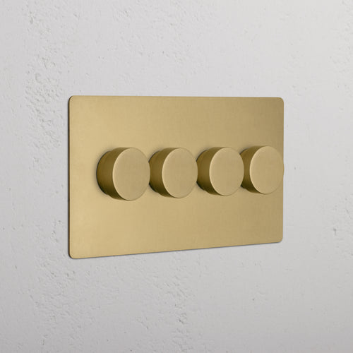 Kew 4G Dimmer Switch in Antique Brass with four round dimmer knobs mounted on a wall.