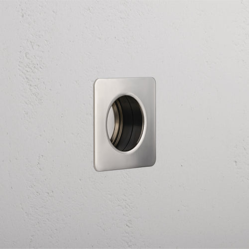 Regent Recessed Small Pull in Polished Nickel, square design with central round recess, mounted on white wall.