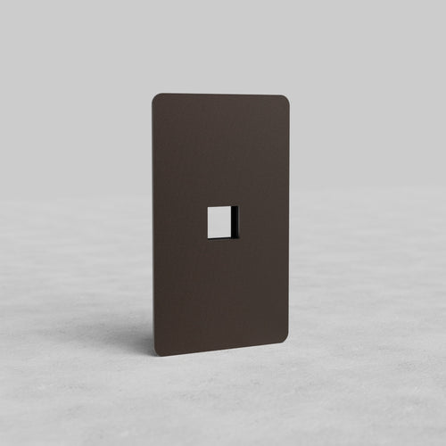 Bronze 1G Keystone Plate Kew US with single keystone cutout, displayed upright on a light gray surface.