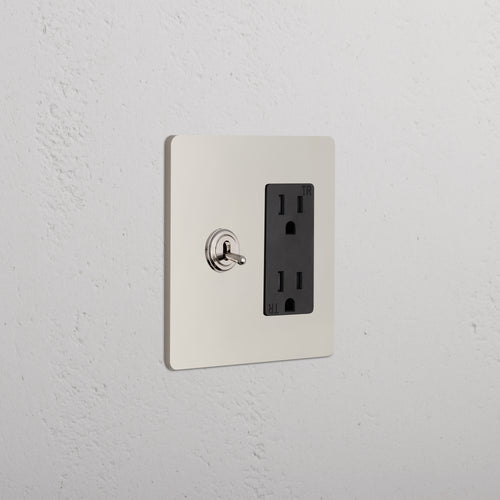 Grove 2G Toggle Switch & Outlet in polished nickel black with toggle switch and black duplex outlet on wall.