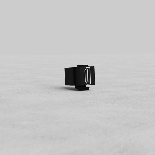 Black HDMI Keystone Module standing upright on a light gray surface with a plain gray background.