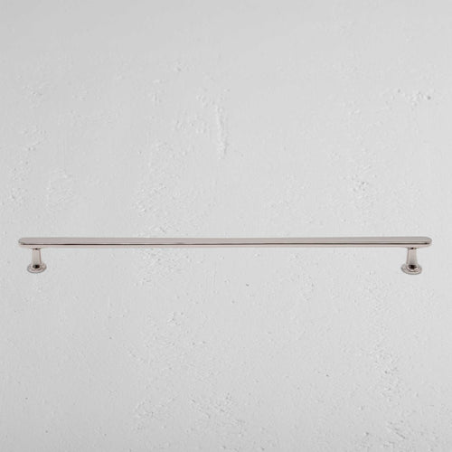 Large Milliner furniture handle in polished nickel finish, mounted horizontally on a white wall.