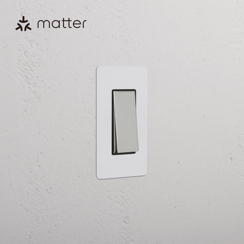 Kew 1G Smart Retractive Rocker Switch in paintable polished nickel black finish, mounted on a wall.