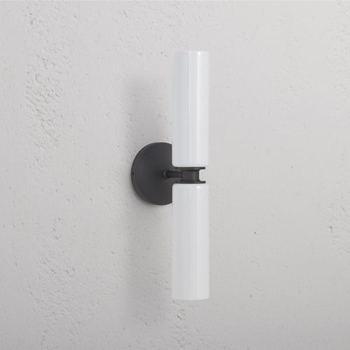 Claremont Medium Wall Light in Fine Porcelain with two white cylinders and a round bronze base, wall-mounted.