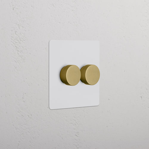Kew 2G Dimmer Switch with two paintable antique brass knobs on a white wall plate.