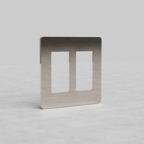 2G outlet plate in polished nickel by Grove US, with two rectangular openings, shown on a light gray surface.