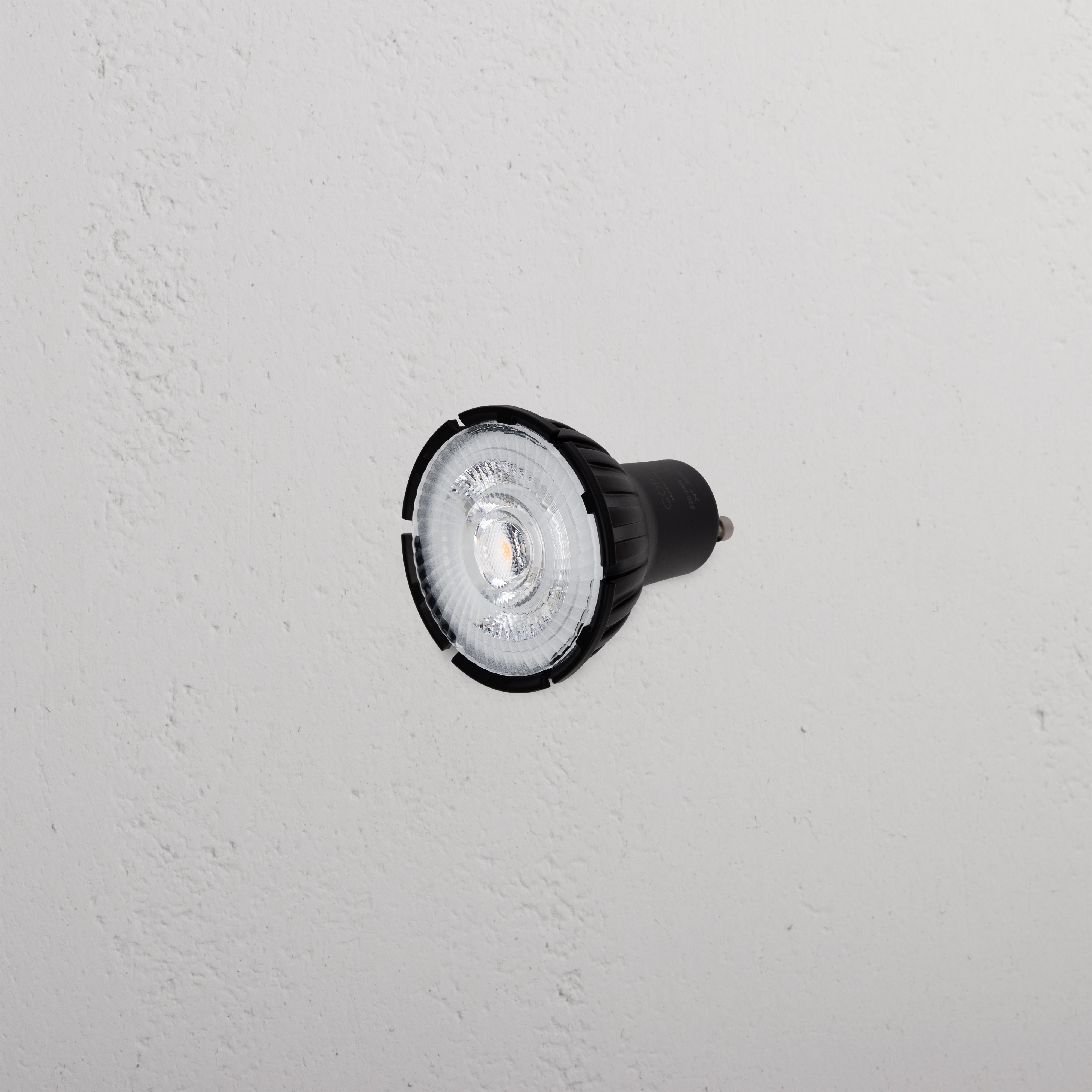 Arthur 7.5W 50mm LED GU10 24° Bulb with black casing displayed against a textured white background.