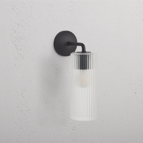 Large Claremont Wall Light Fluted Glass in bronze finish, with vertically fluted glass shade on a wall.