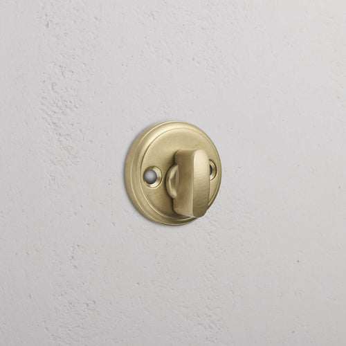Canning Privacy Deadbolt in Antique Brass finish installed on a white wall.