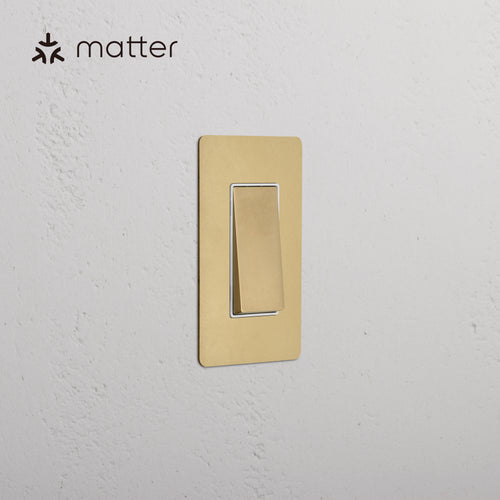 Kew 1G Smart Retractive Rocker Switch in Antique Brass White, mounted on a white wall.
