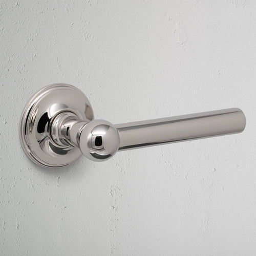 Harper Dummy Door Handle Set in polished nickel with round base, shown mounted on a white wall.