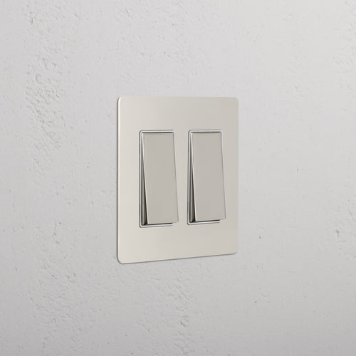 Kew 2G Rocker Switch in polished nickel with white finish, shown mounted on a white textured wall.
