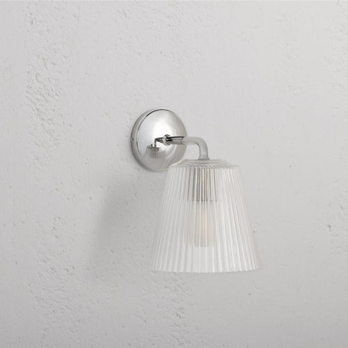 Large Richmond Wall Light with fluted clear glass shade and polished nickel base mounted on a white wall.