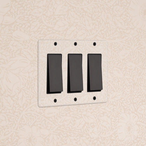Kew 3G Rocker Switch in Clear Bronze Black with three black switches on a clear bronze rectangular plate.