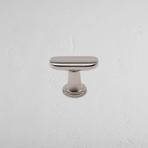 Polished nickel Milliner Furniture Knob with an oval shape, shown against a textured white background.