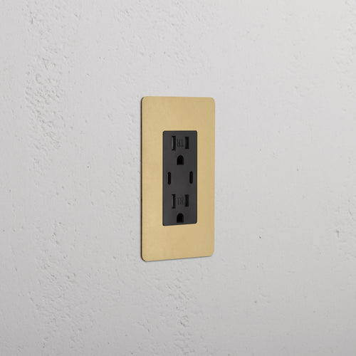 Kew 1G 15A USB Outlet in Antique Brass Black with gold faceplate, installed on a white wall.