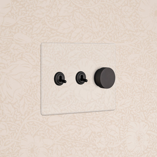 Kew 3G 2x Toggle & Dimmer Switch in Clear Bronze with two toggles and one rotary dimmer on a wall.