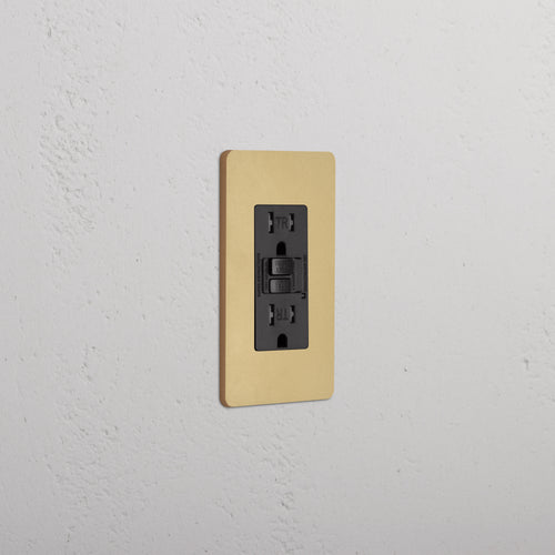 Grove 1G 15A GFCI Outlet in Antique Brass Black finish with test and reset buttons on a wall plate.