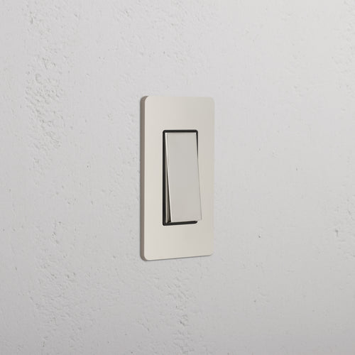 Grove 1G Rocker Switch in Polished Nickel Black, rectangular, mounted on a white wall.