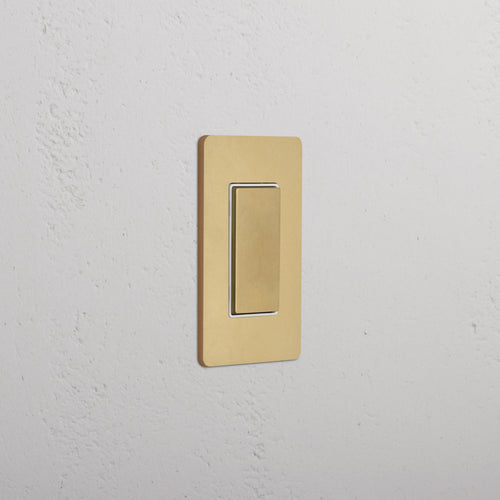 Grove 1G Center Retractive Rocker Switch in Antique Brass White, with gold finish and rectangular plate.