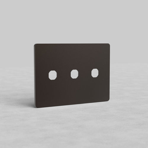 Bronze 3-gang switch plate, Grove US design, with three rectangular switch cutouts on a light surface.