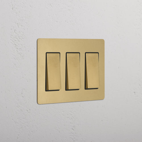 Kew 3G Rocker Switch in Antique Brass Black finish, shown mounted on a wall.