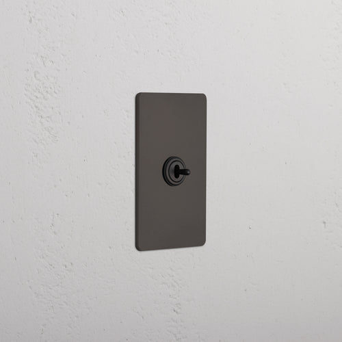 Grove 1G Center Retractive Toggle Switch in bronze with centered toggle and rectangular plate.