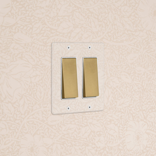 Kew 2G Rocker Switch in Clear Antique Brass White finish, double rocker on white plate, wall mounted.