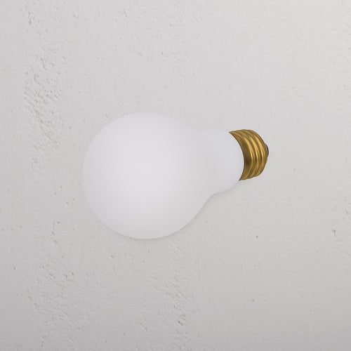 Mulberry 6W LED E26 light bulb with brass screw base resting on a textured white background.