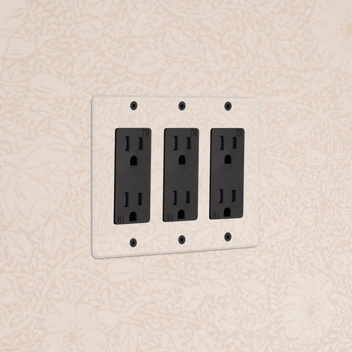 Kew 3G Outlet in clear black finish mounted on a white faceplate against a floral cream wall.