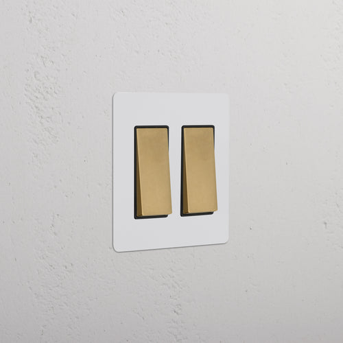 Kew 2G Rocker Switch in paintable antique brass black finish, mounted on a wall.
