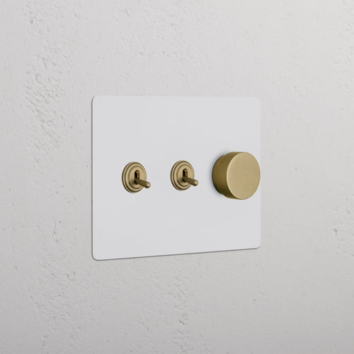 Kew 3G 2x Toggle & Dimmer Switch in paintable antique brass with two toggles and a dimmer knob.