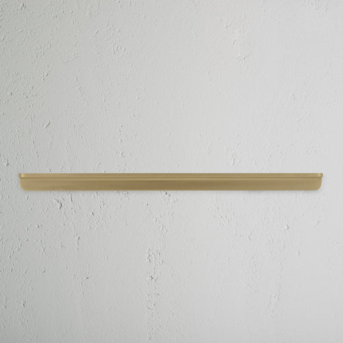 Oxford Furniture Handle Large in antique brass finish, mounted horizontally on a white wall.