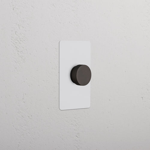 Kew 1G Dimmer Switch in paintable bronze finish with round knob on a rectangular wall plate.