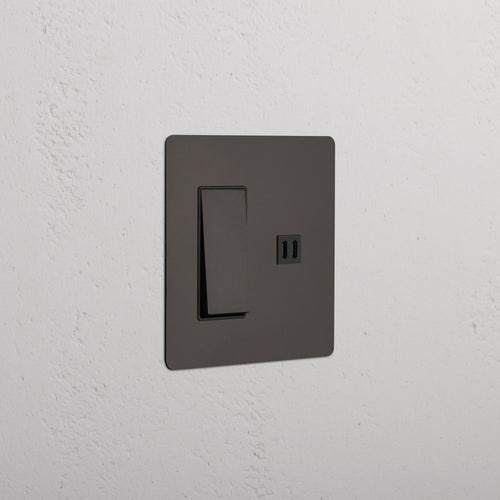 Kew 2G Rocker Switch & Fast Charge USB in Bronze Black with a modern rectangular plate on a wall.