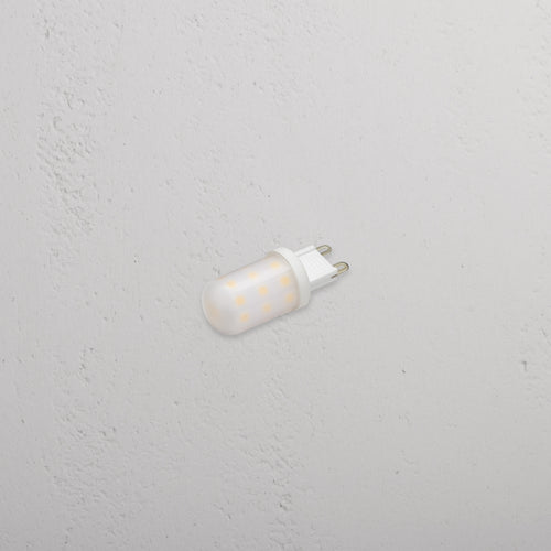 Eden 2.5W G9 LED Bulb with two metal prongs, designed for lighting, on a white textured surface.