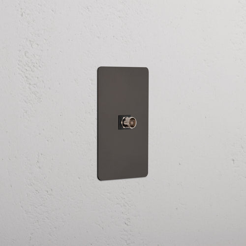 Kew 1G TV Keystone wall plate in Bronze Black with single TV coaxial port, shown on a white wall.
