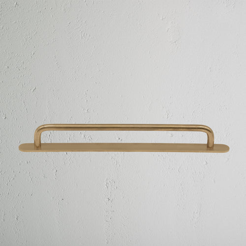 Kilburn Furniture Handle Medium in Antique Brass finish, mounted on a white surface.